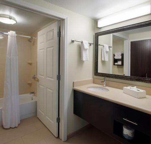 费耶特维尔菲耶特维尔驻桥套房酒店的浴室配有盥洗盆、镜子和浴缸