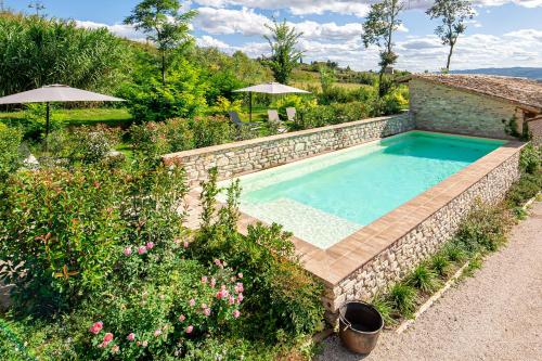 阿西西Borgo Antichi Orti Assisi的一座带石墙的花园内的游泳池