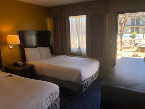 奥德萨Howard Johnson by Wyndham Odessa TX的酒店客房设有两张床和窗户。