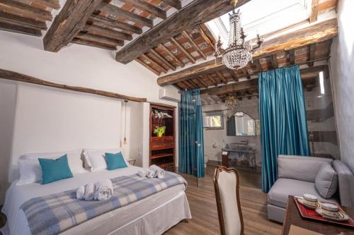 阿雷佐Podere Fontanino的一间卧室配有一张床、一张沙发和一个吊灯。