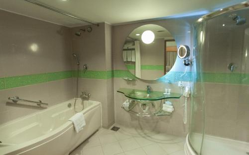 达卡湖滨酒店&公寓的一间带水槽、浴缸和镜子的浴室