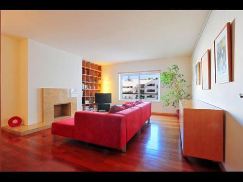 里斯本世博会舒适当代旅馆的客厅设有红色的沙发和壁炉