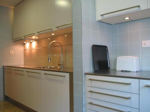 里斯本世博会舒适当代旅馆的厨房配有水槽和台面