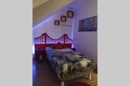 坎佩尔LOGEMENT ATYPIQUE BIEN ETRE AU CŒUR DE LA NATURE的一间卧室配有一张红色床头板的床