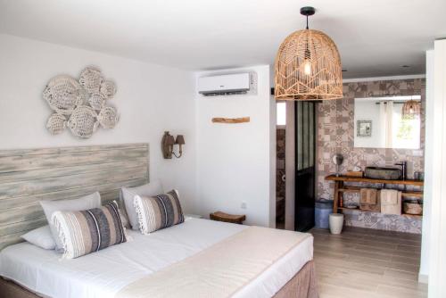 埃尔切Finca Pura, Clothing Optional Guestrooms的卧室配有白色的床和吊灯