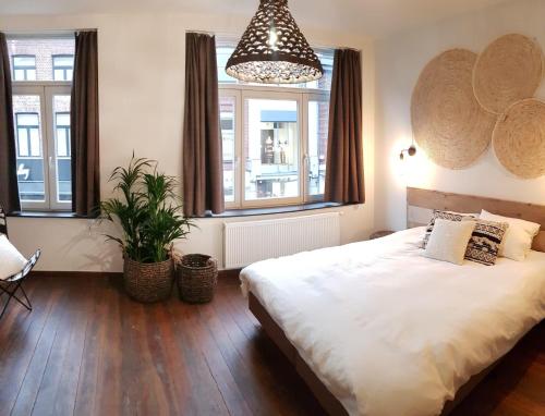 马塞克Anthos B&B的一间卧室配有一张大床和盆栽植物