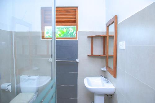 米瑞莎Surf Sea Breeze的一间带水槽和卫生间的浴室以及窗户。