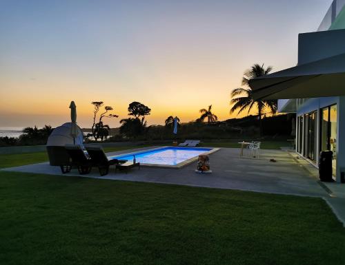 佩达西镇Ocean Breeze Cove - Luxury Retreat的一座房子,设有一座享有日落美景的游泳池