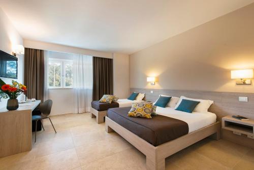 西维尔诺瓦·马尔凯Hotel Dimorae Rooms and Suites - Apartments的酒店客房配有两张床和一张书桌