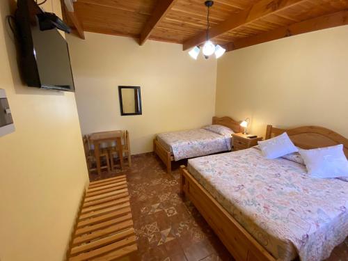 圣佩德罗·德·阿塔卡马Las Cornizas de Catarpe的一间卧室配有两张床和一台平面电视