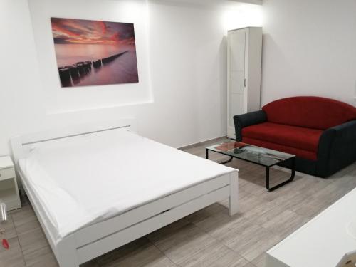 贝尔格莱德Airport view Apartment的一间卧室配有一张床和一张红色椅子
