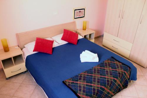 圣玛丽亚Santa Maria flats的一间卧室配有蓝色的床和红色枕头