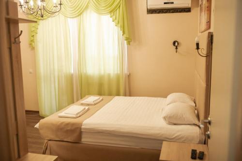 秋明Traveler's Mini-Hotel的一间卧室配有一张床,上面有两条毛巾