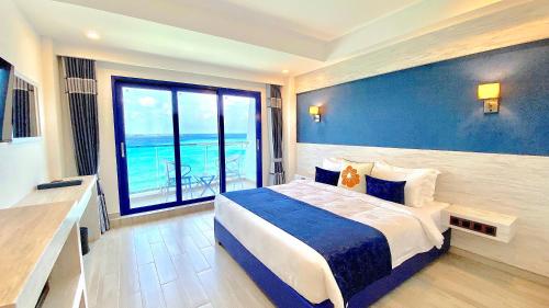 马富施Kaani Palm Beach的一间卧室设有一张大床和一个大窗户