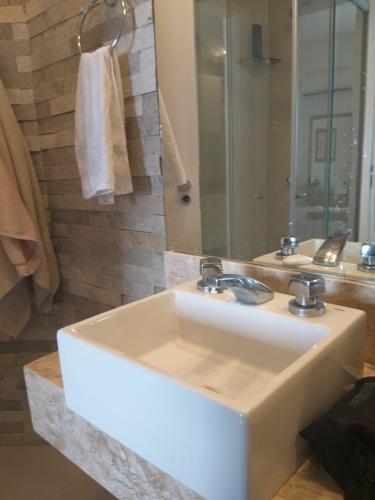 福塔莱萨Flat Beira Mar Golden Fortaleza的浴室设有白色水槽和镜子