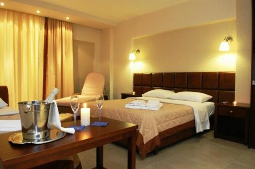 奥林匹亚基·阿克蒂约安娜酒店 的酒店客房,配有床和桌子,配以酒杯