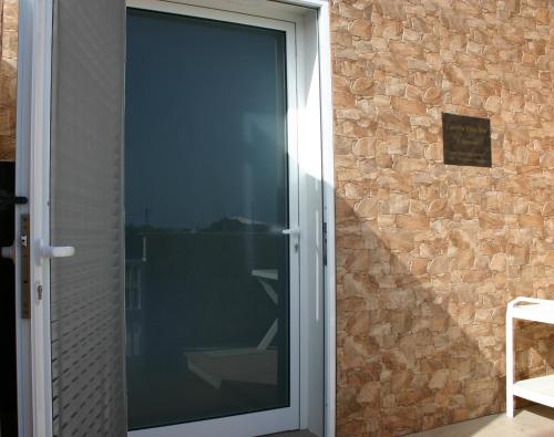 圣港Casinha Vista Mar的推拉玻璃门,带有石墙