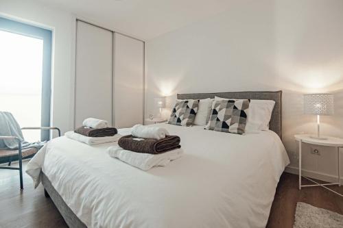 富尔纳斯9 Furnas Villa的卧室配有带毛巾的大型白色床