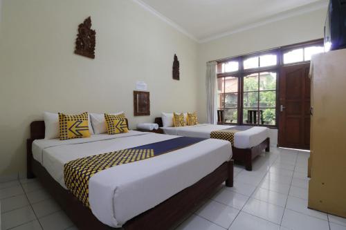 登巴萨SPOT ON 2426 Hotel Aget Jaya Ii的一间卧室设有两张床和窗户。