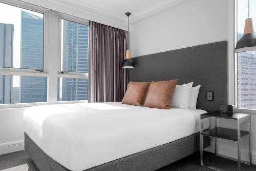 悉尼曼特拉肯特酒店的卧室设有白色大床和窗户。