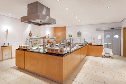 纽伦堡Holiday Inn Nürnberg City Centre, an IHG Hotel的一间餐厅,上面有食物柜台