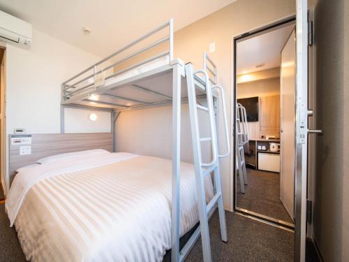 川崎Super Hotel Premier Musashi Kosugi Ekimae的一间卧室配有带梯子的双层床