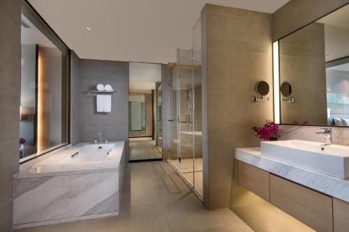 南京南京翠屏新港假日酒店的一间带两个盥洗盆和大浴缸的浴室