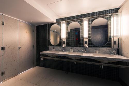 台中市Getcha Hostel的浴室设有3个水槽和3面镜子