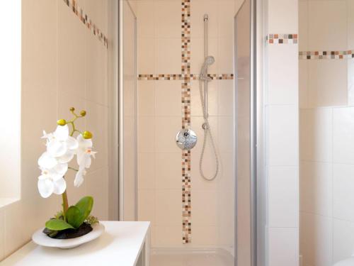 蒂门多夫Haus Seeschwalbe的浴室设有位于柜台上的白色花卉淋浴。