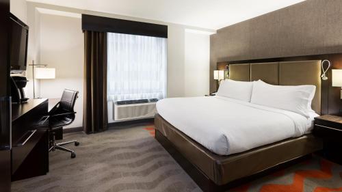 纽约下东城假日酒店的酒店客房配有一张床、一张书桌和一台电视。