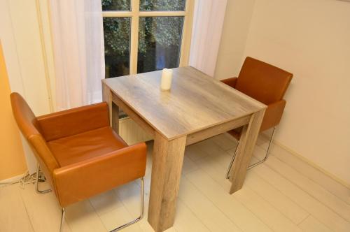 弗利辛恩克莱恩纳世界住宿加早餐旅馆的一张木桌,上面有两把椅子和蜡烛
