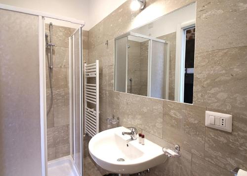 佛罗伦萨Foresteria Sociale Florence Center by New Generation Hostel的一间带水槽、淋浴和镜子的浴室