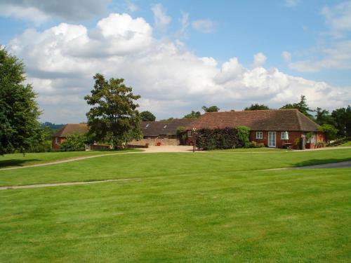 GoudhurstThree Chimneys Farm Accommodation的前面有一个大型绿地的房子