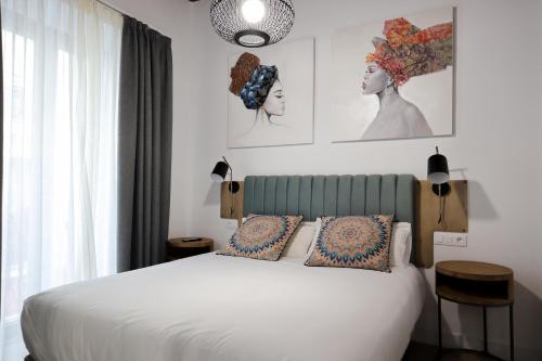 塞维利亚Calma Suites的卧室配有白色的床和2个枕头