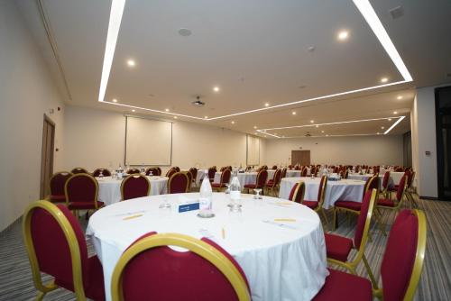 哈马马特金色郁金香塔杰苏尔坦度假村的一间会议室,配有白色的桌子和红色的椅子