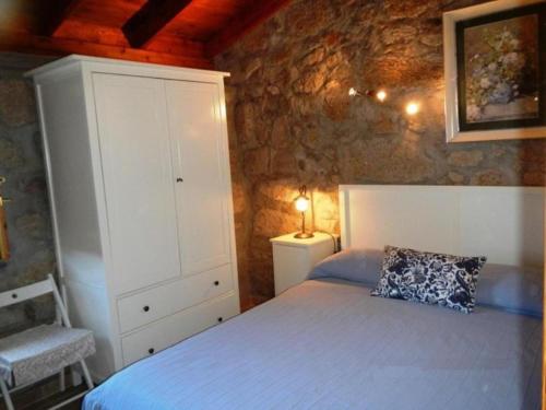 Lomo de AricoRenllon的一间卧室配有一张床、一个橱柜和一个枕头
