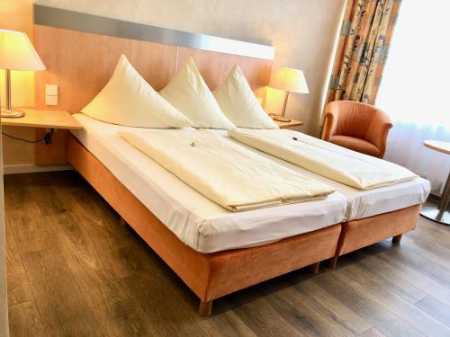 法兰肯塔尔中央酒店的一张大床,位于酒店带书桌的客房内