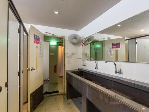 新加坡K2 Guesthouse Central的一间带两个盥洗盆和大镜子的浴室