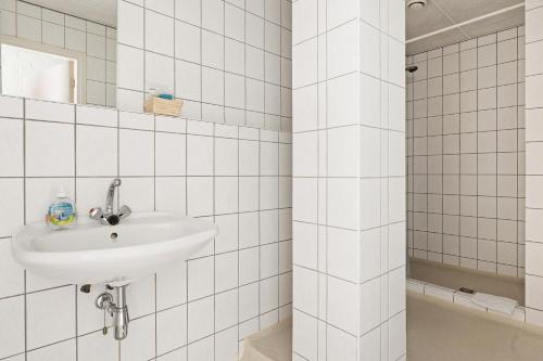 Jipsinghuizen维勒霍夫酒店的白色瓷砖浴室设有水槽和淋浴