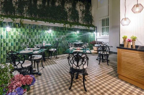 伊斯坦布尔The Soul Istanbul Hotel的一间带桌椅和绿色墙壁的餐厅