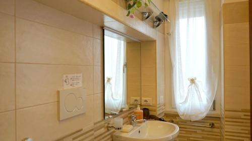 奇维塔韦基亚La Lanterna Sul Comò的一间带水槽和镜子的浴室以及窗户。