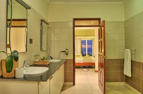 基苏木君豪酒店的浴室配有2个盥洗盆和1个浴缸。