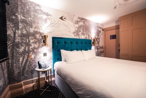 利物浦Lock and Key Boutique Hotel - Duke Street的一间酒店客房,配有一张床和一部电话