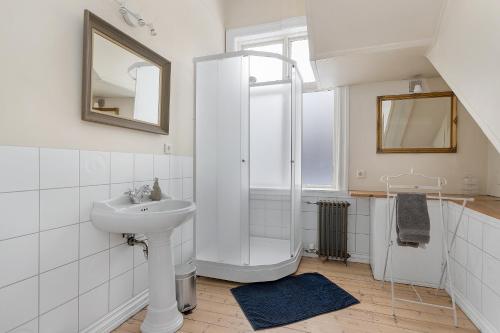 雷克雅未克Sudurgata - Authentic Reykjavik Style Apartment的白色的浴室设有水槽和淋浴。