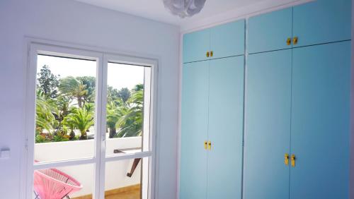 蒙特罗伊Villa Paradise by MarCalma的一间设有蓝色橱柜和窗户的客房