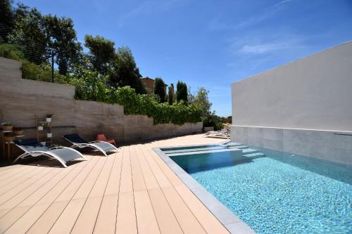 巴古尔Casa Lou, architect villa with heated pool at Begur, 470m2的一个带椅子和围栏的庭院内的游泳池