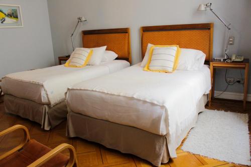瓦尔帕莱索泽罗酒店的配有黄色枕头的酒店客房的两张床