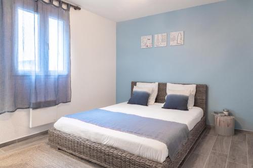 尼斯英国海滨大道舒适公寓的一间卧室设有一张带蓝色墙壁和窗户的大床