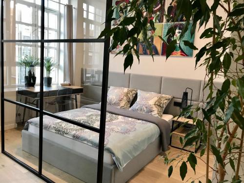 比亚韦斯托克Neon Loft Apartament Bukowskiego的一间卧室配有床和植物