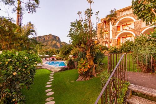 迪坡斯特兰Posada del Tepozteco - Hotel & Gallery的一个带游泳池和大楼的度假庭院